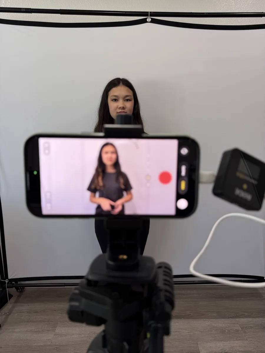 Chloe's phone on a tripod, recording her, with a backdrop and light set up behind